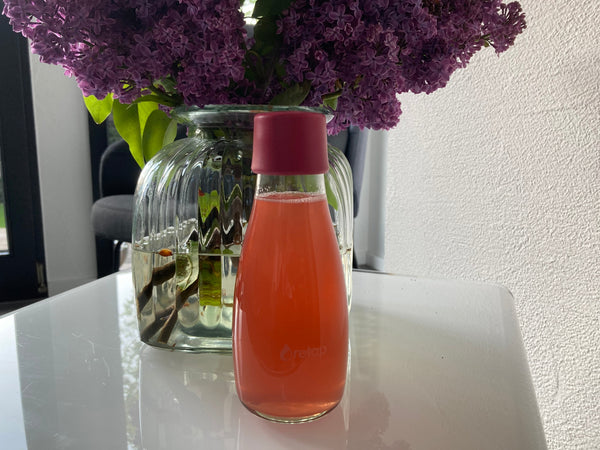 Glastrinkflasche vor Blume
