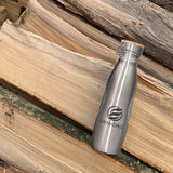 Haymdall-Edition-800ml-limitierte-Edition-Edelstahl-Trinkflasche-silber-mit Edelstahl-Flachverschluss- mit-Bambusplättchen-und-Tragebügel-aus-Edelstahl-auf-Holzstapel-in-der-Natur