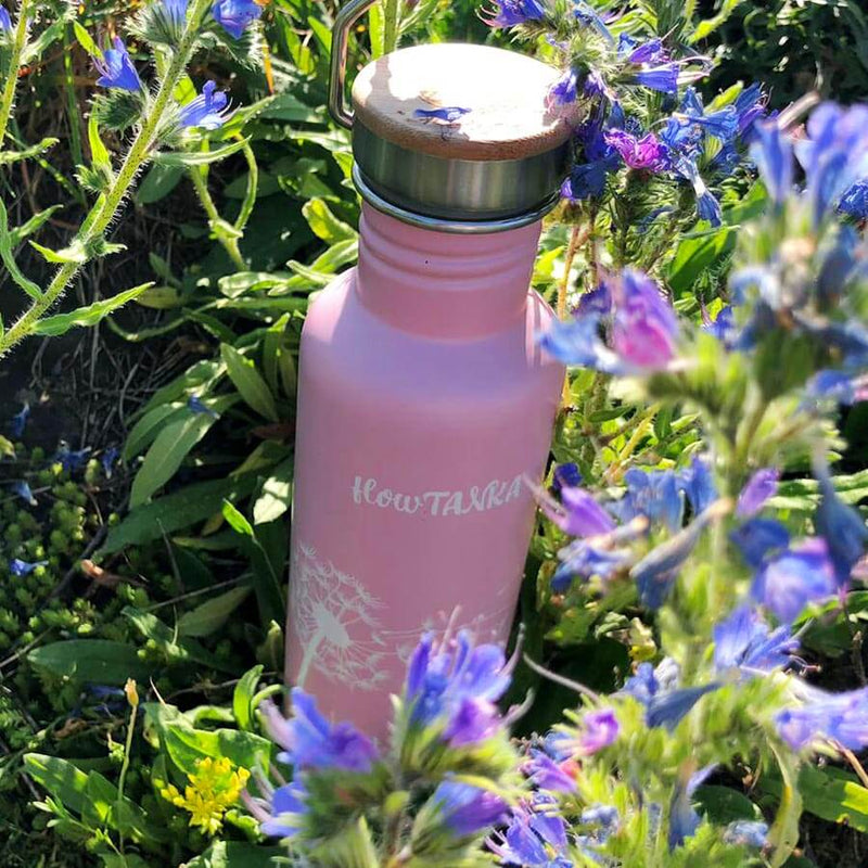 Edelstahl Trinkflasche in rosa mit weißem Blütenmotiv inmitten von bunten Blüten